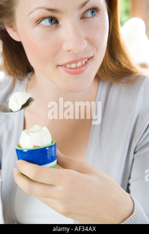 Woman eating egg pour le petit déjeuner Banque D'Images