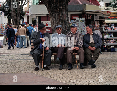 Un groupe d'hommes âgés assis sous un arbre sur la place centrale d'Albufeira Algarve Portugal Banque D'Images