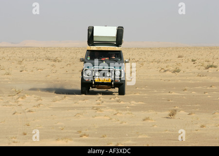 Une Mercedes 230e traversant le désert du Sahara. Banque D'Images