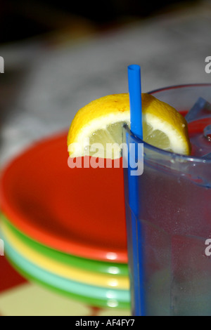 Citron verticale dans un verre d'eau avec des plaques colorées en arrière-plan Banque D'Images