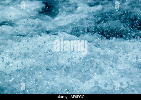 Close up horizontale de la surface de la mer bleue étant agitées et soulevés créer spray blanc Banque D'Images