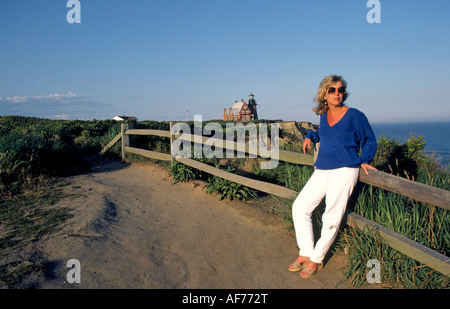 Une femme se tient près du phare de lumière, Block Island, Rhode Island. Banque D'Images