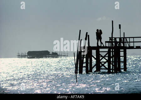 La Malaisie. P. Besar. Silhouette de jeune couple on jetty. Banque D'Images