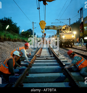 United Kingdom. L'Angleterre. Les hommes travaillant de nuit pose des rails de chemin de fer. Banque D'Images