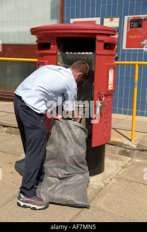Postman la collecte de post postbox du pilier rouge Banque D'Images