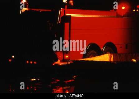 Camion-citerne d'un camion d'incendie et le réservoir sur une décharge, lieux de l'incendie dans la nuit Banque D'Images