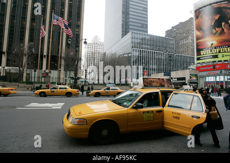 African American female passenger noir sort de la porte arrière du taxi jaune sur la 7e avenue à l'extérieur de new york hotel Banque D'Images