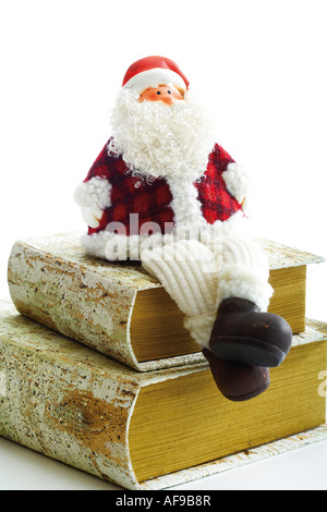 Santa Claus figurine assis sur les livres Banque D'Images