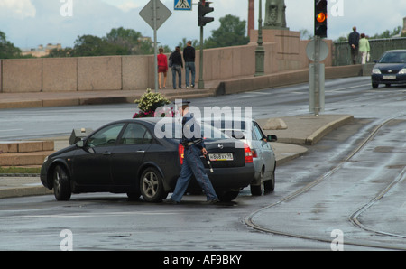 Agent de la circulation avec la baton de la vérification d'une Russie voiture Nissan.St Petersburg Banque D'Images