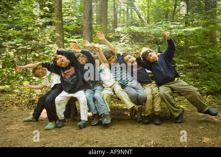 Groupe de jeunes garçons, clown autour sur un banc dans le modèle woods libéré Banque D'Images