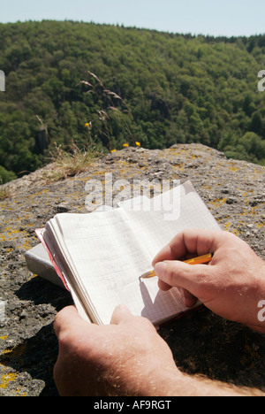 L'homme à écrire des notes dans l'ordinateur portable Banque D'Images