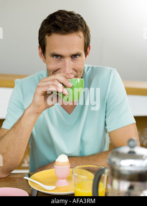 L'homme assis à table de petit déjeuner Banque D'Images