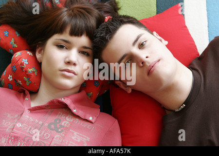 Portrait of teenage couple lying on the floor. Banque D'Images