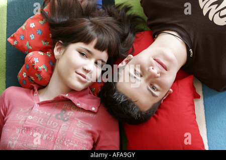 Portrait of teenage couple lying on the floor. Banque D'Images