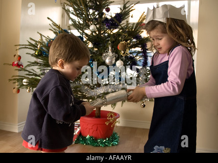 Frère et soeur tirant une Christmas Cracker Banque D'Images