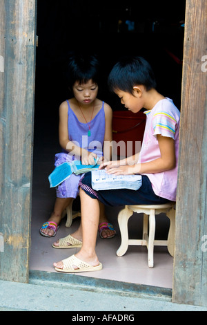 Les filles d'étudier ensemble dans une embrasure de Wuyuan Xiao Likeng Chine Village Banque D'Images