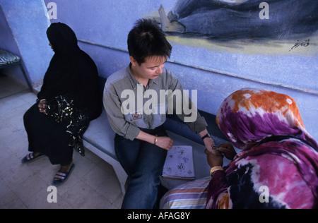 Assouan Egypte Femme de tribu nubienne l'application de henné sur la main de tourisme Banque D'Images