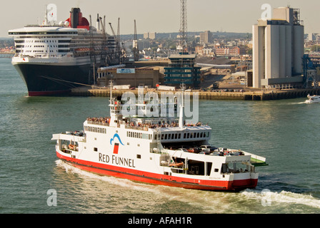 L'île de Wight car-ferry le Falcon rouge vu passer le paquebot de croisière de Cunard le Queen Mary 2 à Southampton Banque D'Images