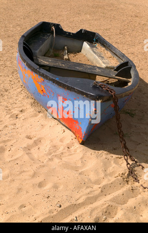 Vieux bateau avec de la peinture à l'abandon sur le sable Banque D'Images