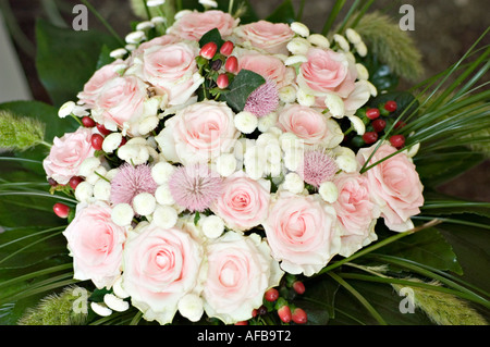 Bel arrangement floral de roses roses roses blanches avec chardons violets, baies rouges et feuilles vertes. Élégant bouquet de mariée ou cadeau floral. Banque D'Images