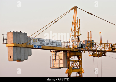Gros plan d'une grue de construction Potain jaune contre un ciel dégagé à Ursynow, Varsovie, Pologne, montrant la cabine, les contrepoids, et jib. Banque D'Images