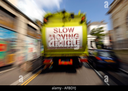 Un panneau de véhicule lent sur le hayon d'une ville de Brighton et Hove camion de recyclage ordures holding up traffic Banque D'Images