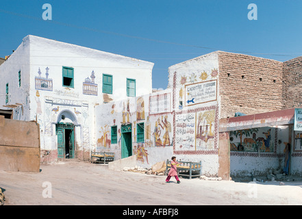 Une fille qui marche devant l'usine d'Albâtre dans un village de maisons arabes peint près de la Vallée des Rois Egypte Banque D'Images