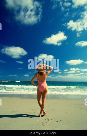 Jeune femme debout sur la plage face à l'Est vers l'océan en West Palm Beach FL Banque D'Images