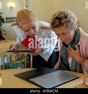 Serveuse en uniforme en tenant un restaurant clients commande et menu Banque D'Images