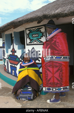 L'Afrique du Sud, Ndebele Mapoch, village près de Pretoria, la femme onversing par chambre avec des peintures murales traditionnelles Banque D'Images