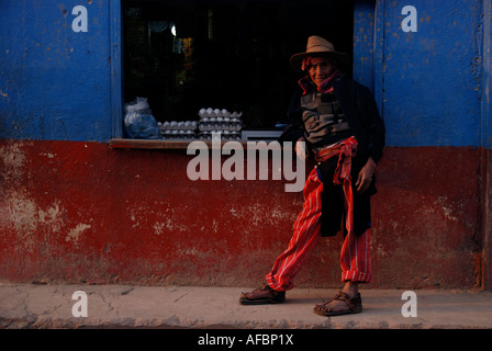 Mayan homme habillé en costume traditionnel local s'appuyant sur comptoir, Todos Santos, Cuchumatans, Guatemala Banque D'Images