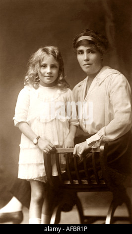 Portrait de jeune fille aux longs cheveux blonds posant avec sa mère vers 1920 Banque D'Images