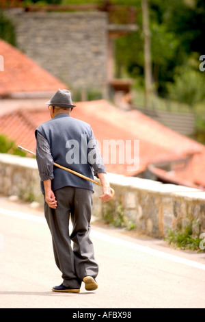 Vieil homme se promenant dans le village et à l'aide d'un bâton de canne à sucre Banque D'Images