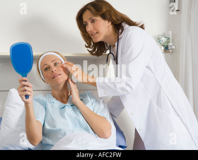 Chirurgien esthétique féminin parlant à female patient Banque D'Images