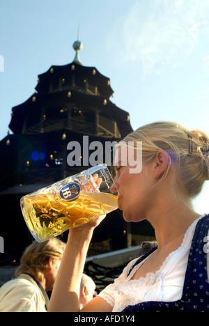 Girl in Dirndl dress la consommation de bière en bière, Chinesischer Turm, jardin anglais, Munich, Bavière, Allemagne Banque D'Images