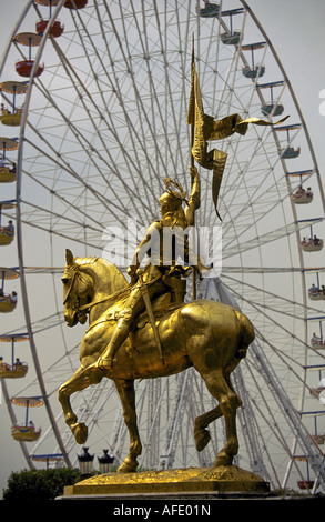 Une statue de Jeanne d'Arc se tient dans la Place des Victoires avec une grande roue dans le jardin des Tuileries, Paris, France. Banque D'Images