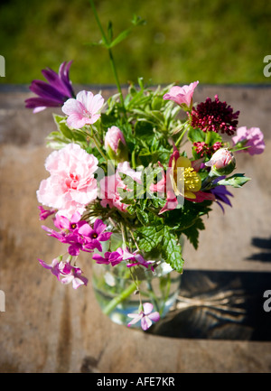 Fleurs d'été mixtes prises dans le jardin, dans un pot de confiture en verre Banque D'Images