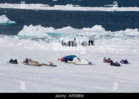 Motoneige et traîneaux ou qamotiqs plus soutenir l'équipe du film zodiac plongée à la banquise dans l'Arctique. Océans Disneynature Banque D'Images