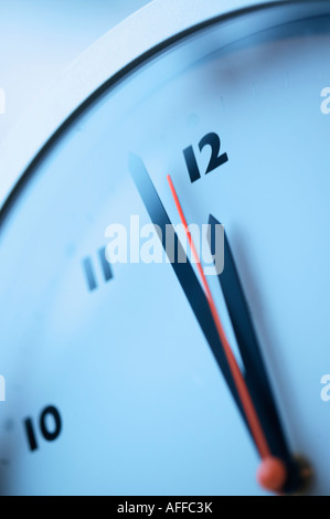 Gros plan d'une seconde main rouge près de minuit sur une horloge murale Banque D'Images