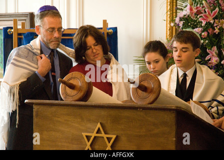 Bar Mitzvah garçon (lits) se lit de la torah aux côtés de ses parents et sa sœur ( bat mitzvah girl) Banque D'Images