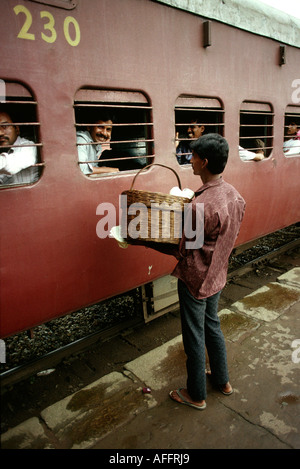 L'Inde Karnataka voyage ferroviaire le transport de denrées alimentaires snack-vendeur fenêtre train Banque D'Images