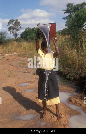 Femme à aller chercher de l'eau à partir d'un lit de rivière à sec, Babati, Tanzanie. Banque D'Images