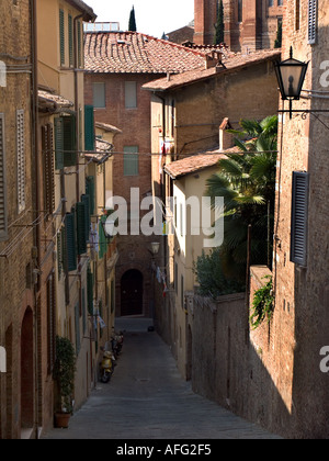 Rue étroite avec des immeubles d'habitation et motorscooters Sienne Italie Banque D'Images