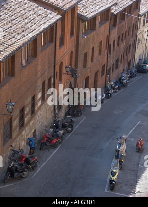 Rue étroite avec des immeubles d'habitation et motorscooters Sienne Italie Banque D'Images