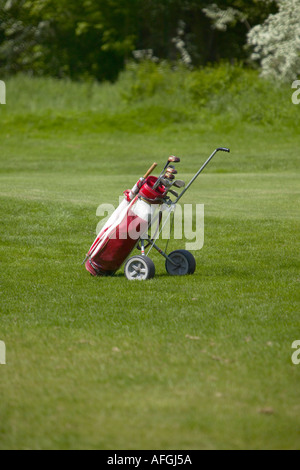 Chariot de golf rouge et blanc garé sur un golf dans le sud de l'Angleterre. Banque D'Images