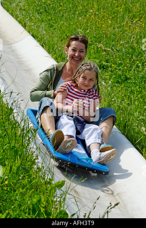 La famille sur une piste de luge d'été en faisant glisser avec toboggans à l'Blomberg près de Bad Toelz Deutschland Banque D'Images