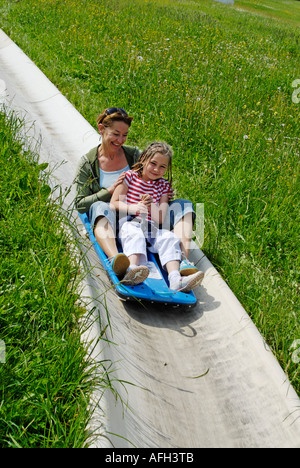 La famille sur une piste de luge d'été en faisant glisser avec toboggans à l'Blomberg près de Bad Toelz Deutschland Banque D'Images