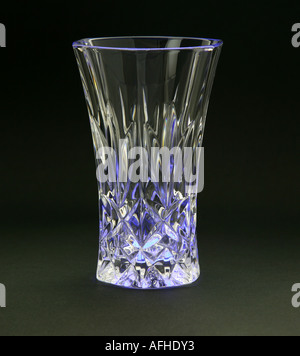Un vase en cristal sur du papier de couleur noir avec une lumière brillant de dessous et en mettant en lumière la tendance coupe tourné en studio Banque D'Images