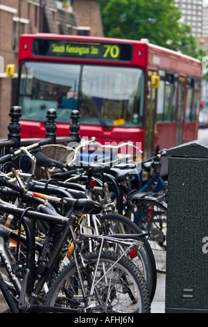 Les vélos garés la rue comme red bus London England UK approches Banque D'Images