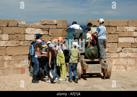 Collégiens le voyage d'une journée à jouer sur un canon vieux remparts Skala de la Ville Essaouira Maroc côte atlantique de l'Afrique du Nord Banque D'Images